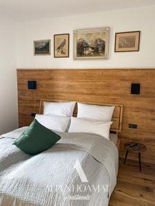 加尔米施-帕滕基兴Alpenhoamat Apartments的一间卧室配有一张大床和木制床头板