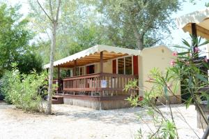 维亚雷焦Chalet in Toskana Viareggio Italie nabij Zee, Strand, Airconditioning, Zwembad, Wifi的海滩上树木背景的房子