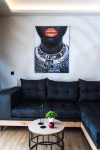 玛利亚Nuovo Luxury Suite的客厅配有黑色沙发和绘画作品