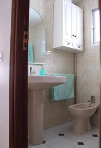桑亨霍Playa Panadeira的一间带水槽、卫生间和镜子的浴室