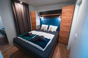比奥格勒·纳·莫鲁Mobile Home Symphony的一间卧室配有一张大床,提供蓝色的床单和枕头