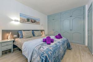 圣地亚哥港Ocean View Suite with beach private access的卧室配有2条紫色毛巾(床上)