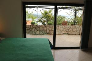 奥帕提亚Apartments Komel II的卧室设有滑动玻璃门,可通往庭院。