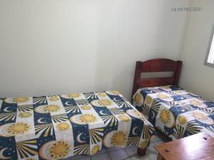 伊塔波阿Sobrado para temporada 200m da praia Itapoá SC的一间卧室配有两张床和一张木椅