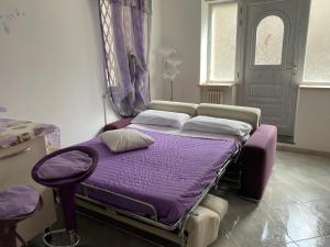 法布罗La Bomboniera di Marco的一张带紫色床单和枕头的床