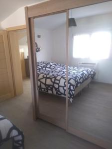 孔特雷克塞维尔Au fil du bois的一间卧室设有一张床和一个滑动玻璃门