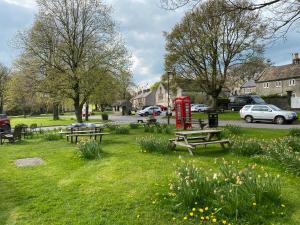 泰德斯韦尔Primrose cottage的公园设有野餐桌和红色电话亭