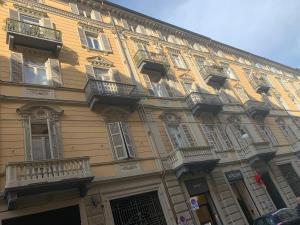 都灵Maria Vittoria House的大型黄色建筑,设有窗户和阳台