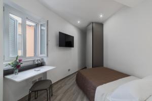 诺尔马B&B Piazza Roma的一间卧室配有一张床、一张书桌和一台电视。