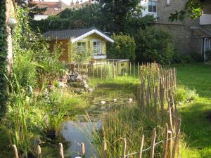 敦刻尔克Rêve Bleu的房屋前带池塘的花园