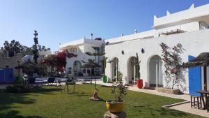 Ghazoua大巴别墅酒店的庭院,白色建筑的庭院,院子里有植物