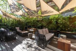 圣地亚哥The Place的木制甲板上配有藤椅和桌子的庭院