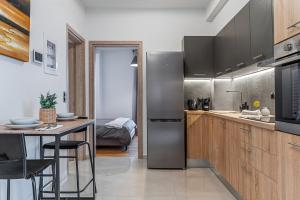 雅典Athena Studio in Gazi的厨房配有不锈钢冰箱和桌子