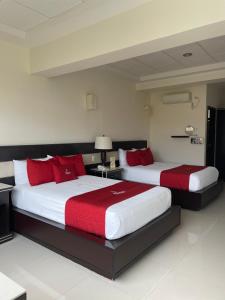 贾拉普维拉拉斯马格利塔卡科斯别墅酒店的两张位于酒店客房的床铺,配有红色枕头