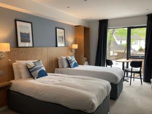 巴洛赫Loch Lomond Hotel的酒店客房设有两张床和一张桌子。