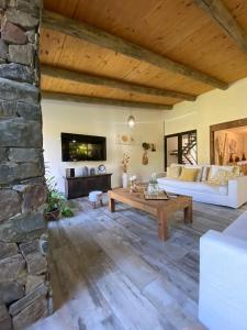 科洛尼亚-德尔萨克拉门托CASA MIA bednbreakfast的客厅配有桌子和石墙