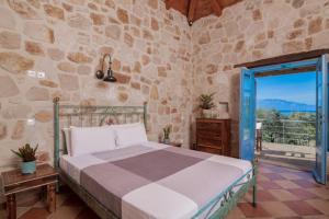 沃丽曼村Strofilia Stone Residences的一间卧室设有一张床和石墙