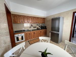 拉拉古纳Exclusive Las Gavias的厨房配有白色的桌子和冰箱。