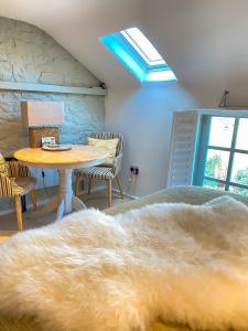 MickletonThe Loft in the Malt Barn Chipping Campden的一间卧室配有一张床和一张桌子,铺有地毯