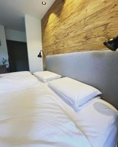 沃尔特湖畔佩莎赫小猫宾馆的卧室设有两张白色的床和木制床头板