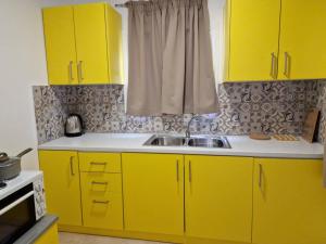 阿彻奇洛斯SOLYMAR PRIVE的厨房配有黄色橱柜和水槽