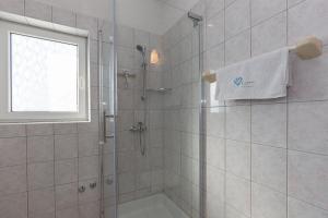 比奥格勒·纳·莫鲁Apartments Dalmata的带淋浴的浴室和玻璃门