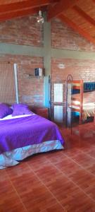 Estancia ViejaCasa Vieja Estancia的一间卧室配有一张床,铺有木地板