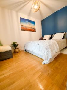 伊西莱穆利诺Cozy 2 pièces AUX PORTES DE PARIS !的一间卧室设有一张床和蓝色的墙壁
