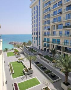 拉斯阿尔卡麦Summer By The Sea Ultra Luxe 1 bedroom Apartment with a private beach - Al Marjan Island的享有棕榈树和大海建筑的空中景致