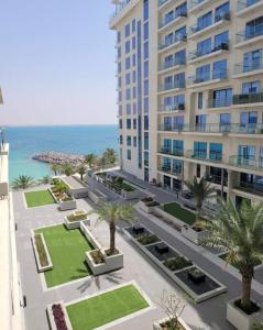 拉斯阿尔卡麦Ocean Whisper Ultra Luxe 1 bedroom Apartment with a private beach - Al Marjan Island的享有棕榈树和大海建筑的空中景致