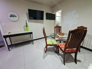 圣何塞Fully-equipped 2-bedroom apartment in San José的客厅配有桌椅和电视。