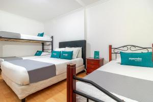 波哥大Ayenda 1032 Titas House的一间卧室配有两张双层床和蓝色枕头