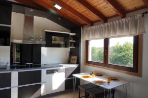 贡多马尔Pedra Moura Casa Rural的厨房配有黑白橱柜和桌子