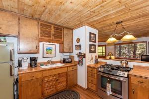 大熊湖008 - Bear Haven的厨房配有木制橱柜和炉灶烤箱。
