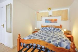 雅茅斯Port Side的一间卧室配有一张带蓝色和白色棉被的床