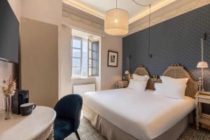 埃姆布能Hotel la Robeyere; BW Signature Collection的酒店客房设有一张白色大床和一张书桌