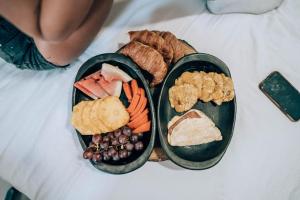 卡塔赫纳Neos Hotel Cartagena的床上有不同食物的两盘