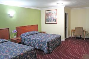 波莫纳罗伊拉汽车旅馆的酒店客房设有两张床和一张桌子。