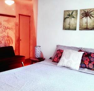 普拉亚弗拉明戈Cabinas Flamingo的一间卧室配有一张带白色毯子和棕榈树的床。