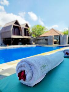 佩母德兰The Bali Menjangan Boutique Villas & Dive Center的游泳池旁的桌子上坐着毛巾