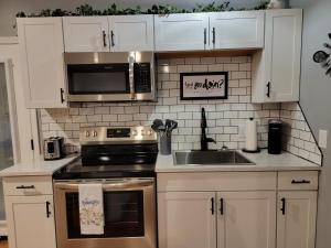 丹德里奇Just Dance的厨房配有白色橱柜、炉灶和水槽。