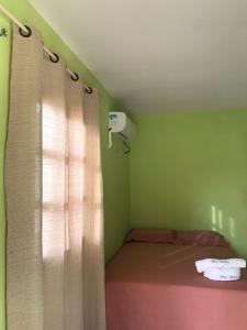 BarroquinhaMar Aberto_chale 3的小房间设有床和带窗帘的窗户