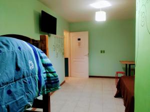 皮拉米德斯港COMPLEJO ALOHA的一间卧室设有绿色的墙壁、一张床和一扇门