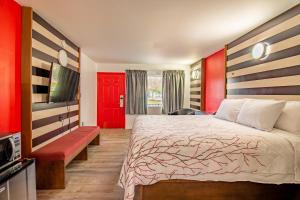 阿什维尔The Asheville Inn的一间酒店客房,配有一张床和一扇红色的门