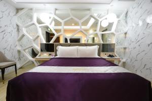 芦竹水立方汽车旅馆的一间卧室设有紫色的床和白色的墙壁