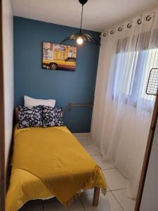 滨海阿热莱斯Bienvenue dans le ROUSSILLON的一间卧室设有黄色的床和蓝色的墙壁
