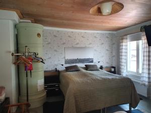 塞伊奈约基Siirilän tila的一间卧室设有一张床和木制天花板