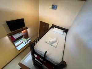 通萨拉First and Frang Hotel - Koh Phangan的小房间设有床铺和电视