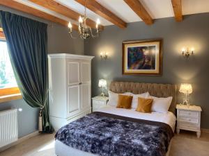 布朗喀尔巴阡木屋酒店的卧室配有一张床,墙上挂有绘画作品