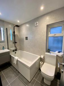 莫克姆Eden Retreats Serviced Apartments的带浴缸、卫生间和盥洗盆的浴室